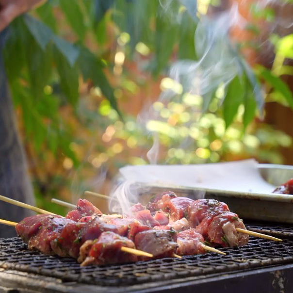 Lamb skewers on a backyard grill. The classic Italian Grigliata, or Barbeque.